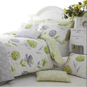 Floral bedding set on a bed with a white headboard and nightstand.