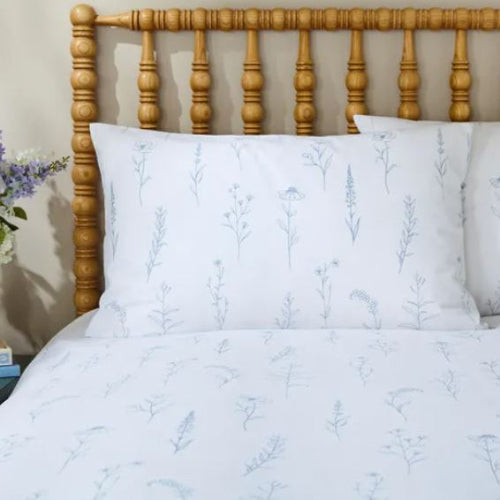 White bedding with floral pattern on a wooden bed frame
