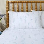 White bedding with floral pattern on a wooden bed frame