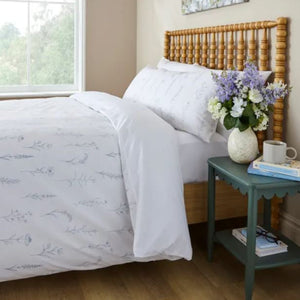 Bedroom with a wooden bed and floral arrangement on a nightstand