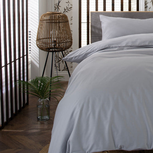 Silver grey bedding set on a bed with a decorative headboard and room decor.