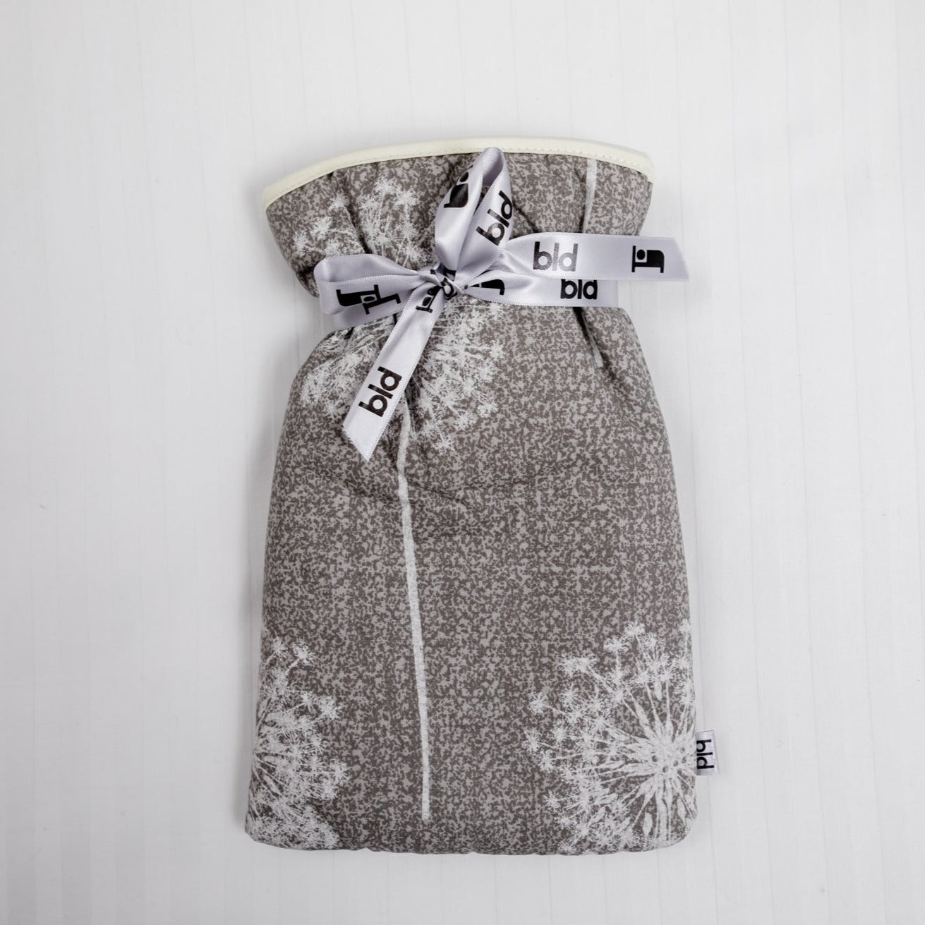 Small hot water bottle with soft padded grey cover