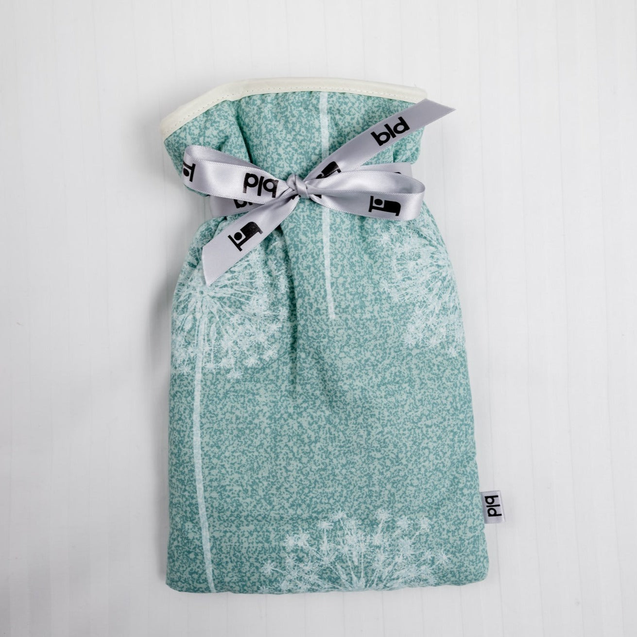 Small hot water bottle with soft padded floral aqua cover